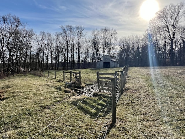 view of yard with a rural view and an outdoor structure