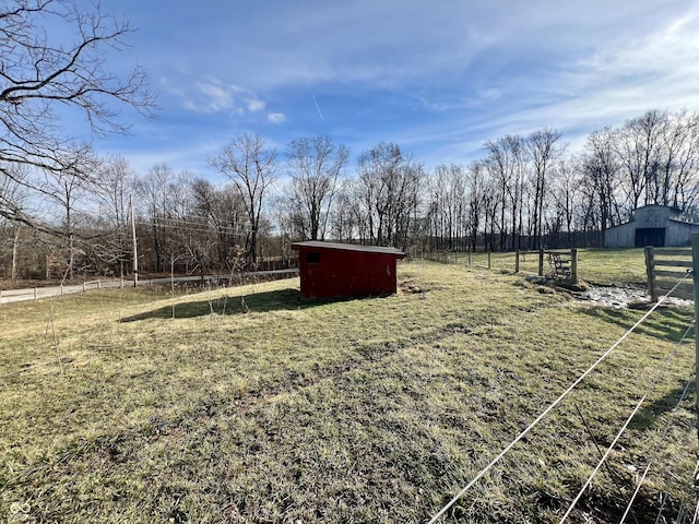 view of yard with an outdoor structure and a rural view