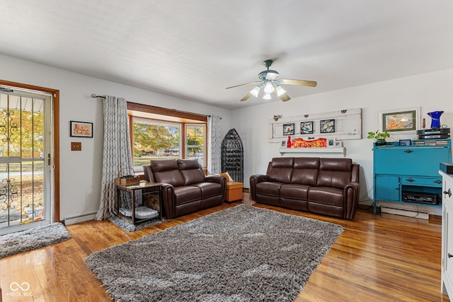 living room with hardwood / wood-style floors, baseboard heating, and ceiling fan