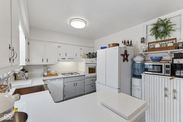 kitchen with sink, white cabinets, decorative backsplash, and stainless steel appliances