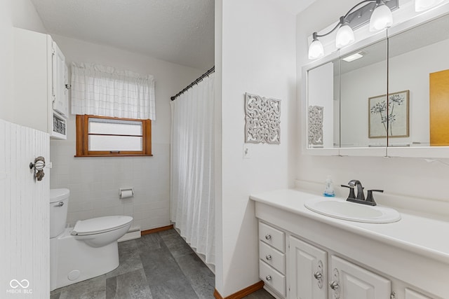 bathroom featuring toilet, vanity, a shower with shower curtain, tile walls, and a textured ceiling