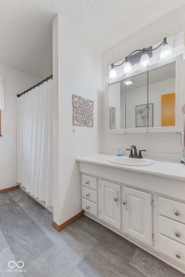 bathroom with vanity, a textured ceiling, and a shower with curtain