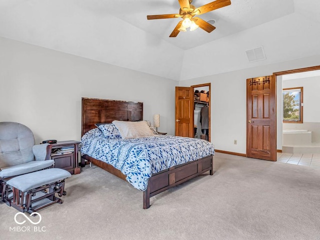 carpeted bedroom with a spacious closet, ensuite bathroom, vaulted ceiling, and ceiling fan