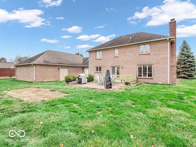 rear view of house featuring a yard, a patio, and a deck