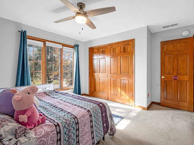 carpeted bedroom featuring ceiling fan and a closet