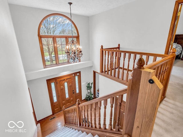 foyer entrance with light hardwood / wood-style floors and an inviting chandelier