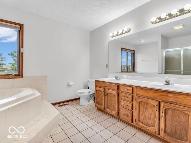 full bathroom featuring tile patterned floors, vanity, a textured ceiling, separate shower and tub, and toilet