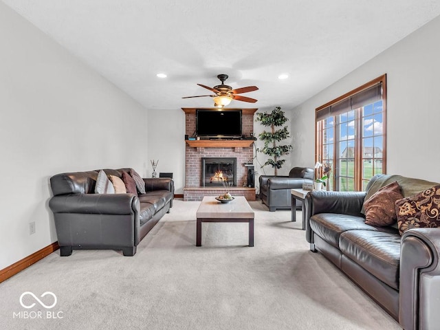 carpeted living room with ceiling fan and a fireplace