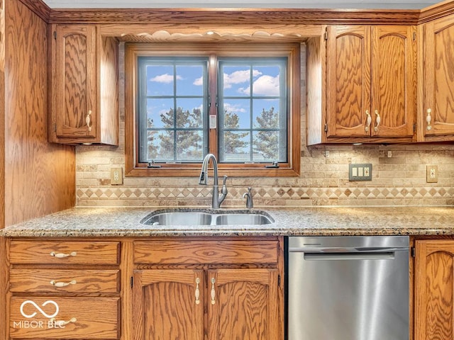 kitchen with decorative backsplash, light stone counters, stainless steel dishwasher, and sink