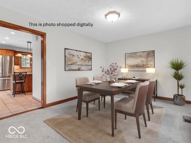 carpeted dining space with a textured ceiling