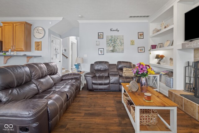 living room featuring dark wood-type flooring, ornamental molding, and built in shelves