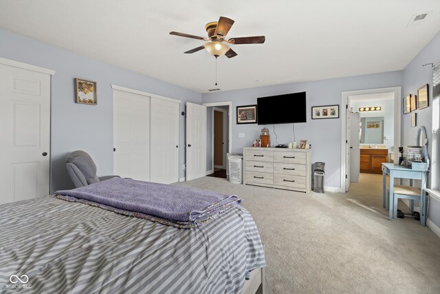 bedroom featuring ensuite bath, light carpet, and ceiling fan