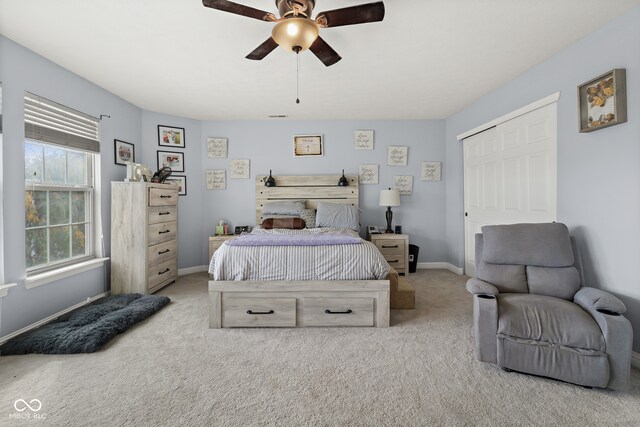 bedroom with light colored carpet, a closet, and ceiling fan