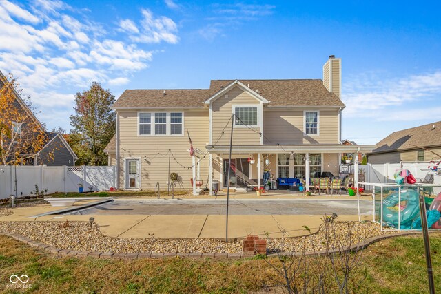 rear view of house with a patio and a swimming pool