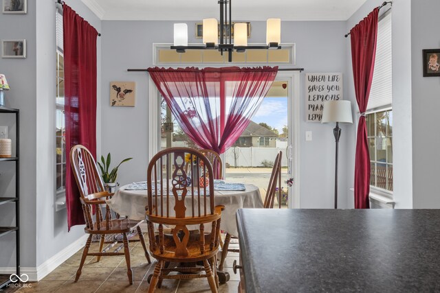 tiled dining room with ornamental molding and a chandelier