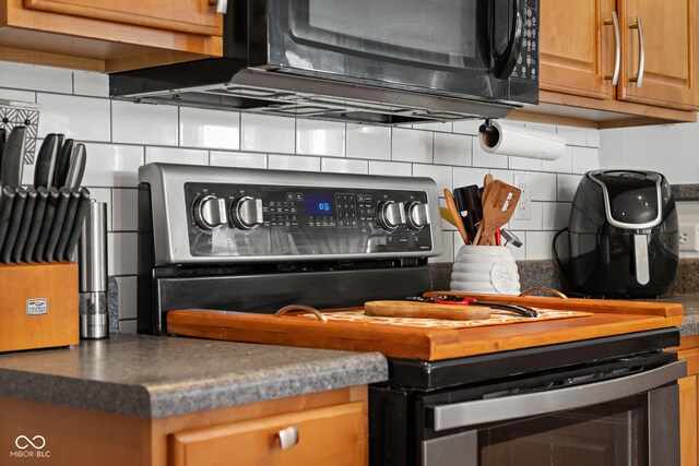 kitchen featuring decorative backsplash and black appliances