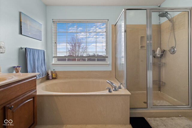 bathroom with vanity and shower with separate bathtub