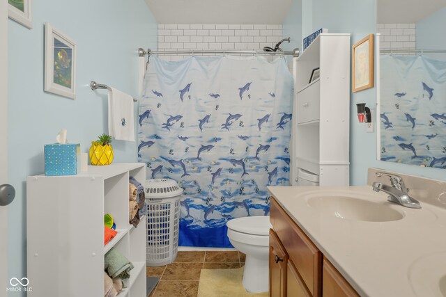 bathroom featuring toilet, vanity, a shower with shower curtain, and tile patterned flooring