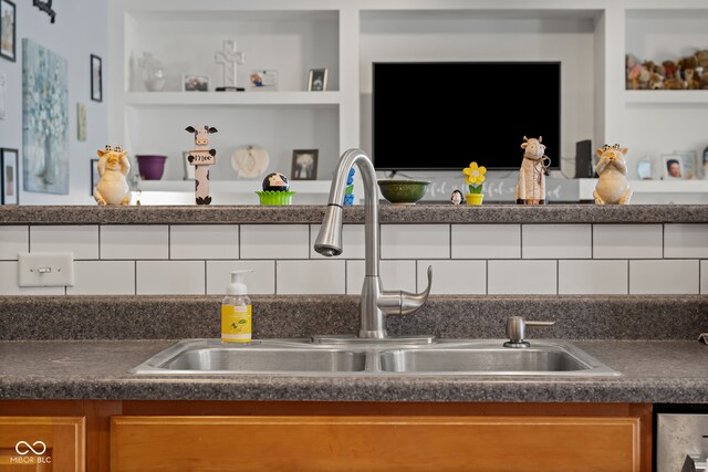 kitchen featuring sink, decorative backsplash, and built in shelves