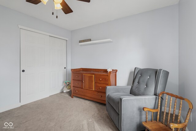 living area with light carpet and ceiling fan