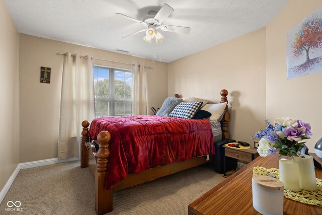 carpeted bedroom featuring ceiling fan and a textured ceiling