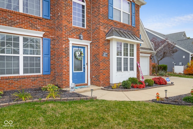 property entrance featuring a yard and a garage