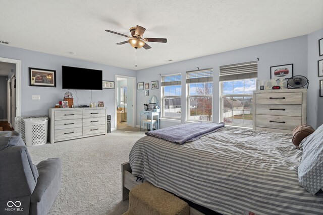 bedroom featuring connected bathroom, carpet, and ceiling fan