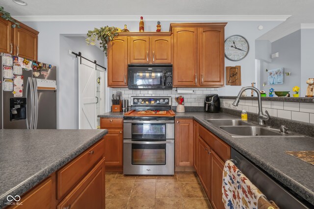 kitchen with stainless steel appliances, ornamental molding, sink, a barn door, and tasteful backsplash