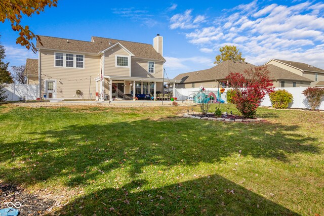 back of property with a patio area and a lawn