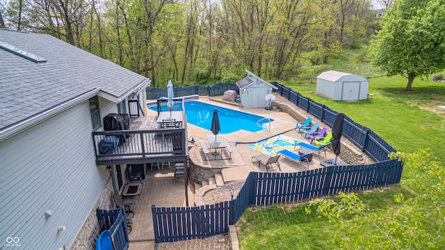 view of swimming pool featuring a patio, a storage unit, and a lawn