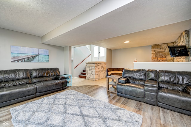 living room featuring light hardwood / wood-style flooring and a textured ceiling