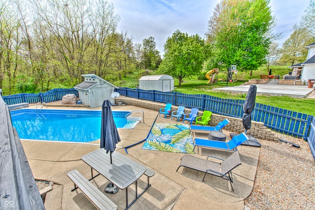 view of pool with a patio area and a storage unit