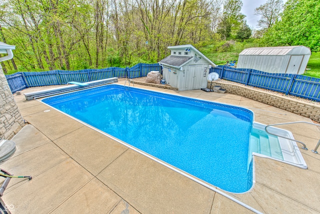 view of swimming pool featuring a patio and a storage shed