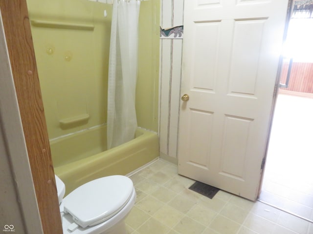 bathroom featuring toilet and shower / bath combo with shower curtain