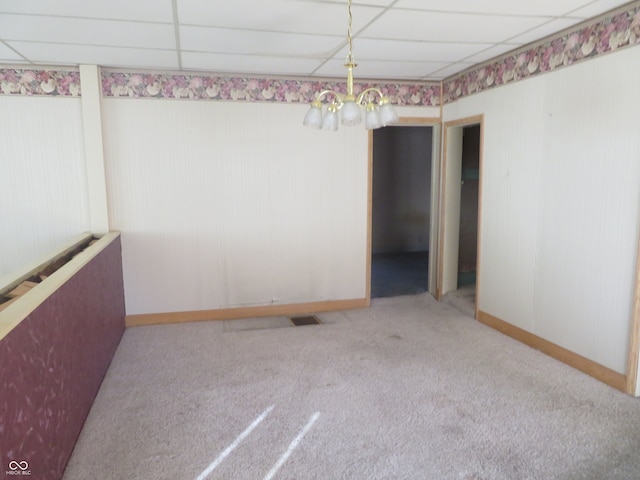 unfurnished room featuring a drop ceiling and light colored carpet