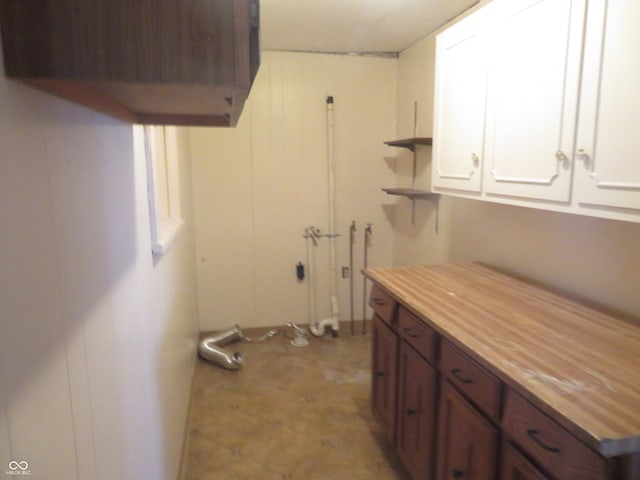 clothes washing area with cabinets