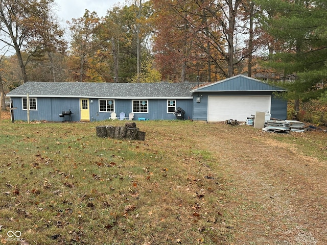 rear view of property featuring a yard, an outbuilding, and a garage