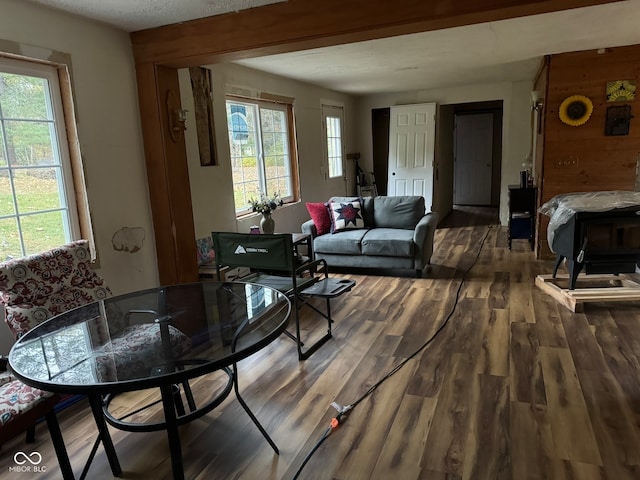 living room with a textured ceiling, a wealth of natural light, wooden walls, and dark hardwood / wood-style flooring