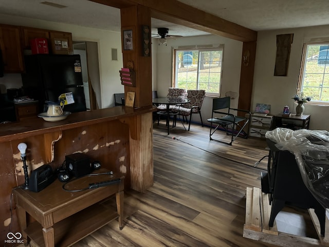 interior space with hardwood / wood-style flooring, ceiling fan, and black fridge