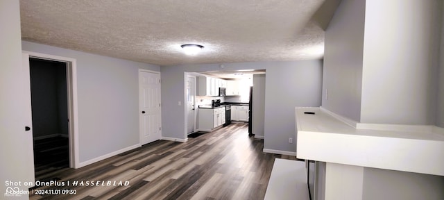 hallway featuring a textured ceiling and dark hardwood / wood-style flooring