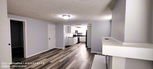 12544 S State Road 3, Westport, IN 47283 - kitchen with white cabinets, a textured ceiling, dark wood-style flooring, baseboards, and freestanding refrigerator