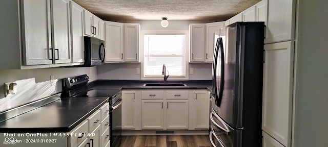 kitchen featuring black appliances, sink, a textured ceiling, dark hardwood / wood-style flooring, and white cabinetry