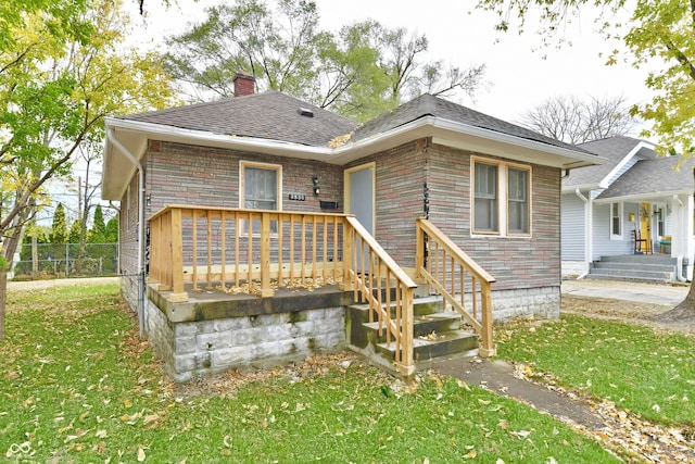 view of front facade featuring a wooden deck and a front lawn