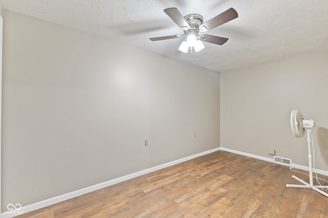 spare room featuring a textured ceiling, wood-type flooring, and ceiling fan