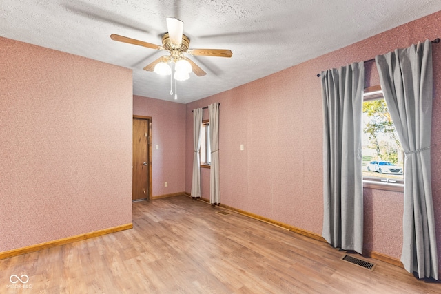 unfurnished room featuring light hardwood / wood-style floors, a textured ceiling, and ceiling fan