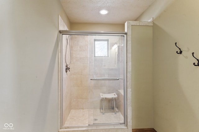 bathroom with a textured ceiling and walk in shower