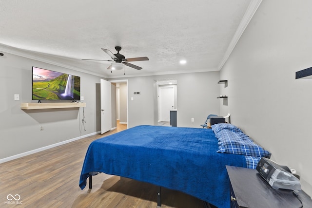 bedroom with crown molding, hardwood / wood-style floors, a textured ceiling, and ceiling fan