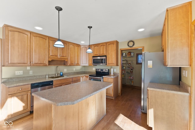 kitchen featuring a kitchen island, sink, stainless steel appliances, and wood-type flooring