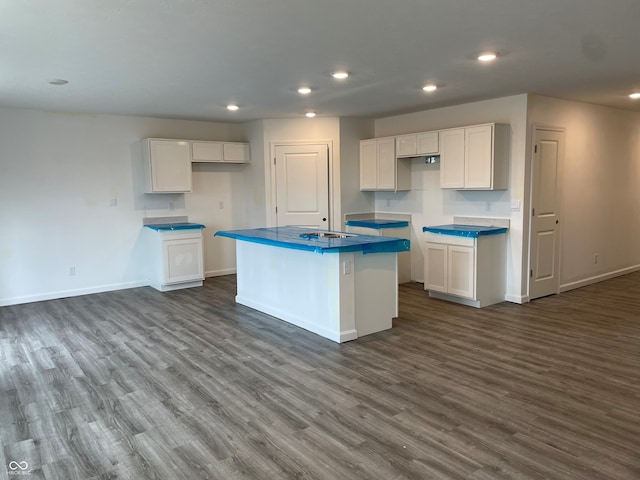 kitchen featuring white cabinets, a kitchen island, and dark hardwood / wood-style flooring