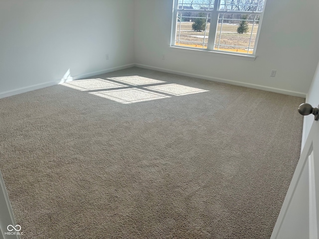 carpeted empty room with baseboards